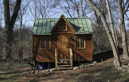 Front view of the Nashville Wonderland tiny home, in its forest surroundings.