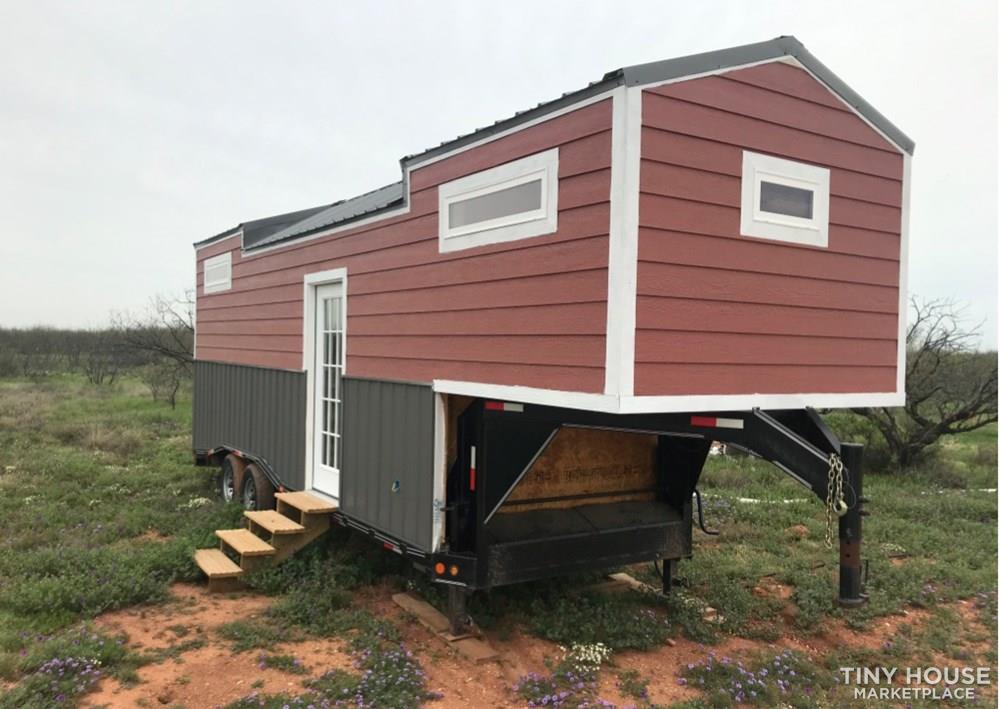 A gooseneck tiny house from Breckenridge, Texas with three windows to the front and side and a windowed single front door.