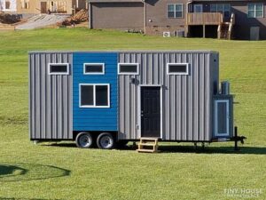 External photo of the Jefferson-based tiny home on wheels, with 5 windows and a solid front door.