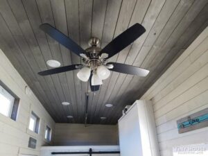 A look at the ceiling, with a large ceiling fan/light, various round LED ceiling lights and 3+ windows.