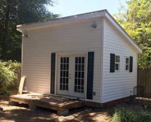 Final version of Less Everything's backyard office shed building, with siding added.