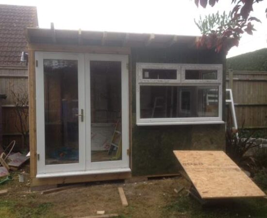 A work in progress photo of Roger Perkin's garden office shed, with UPVC doors and windows added. Roof and internals still need finishing off.