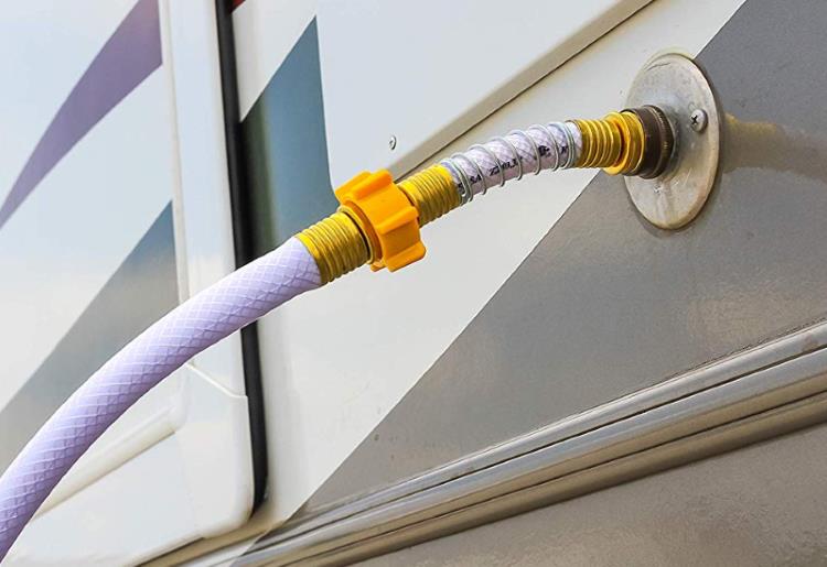 A hose connecting to the RV water outlet connection point, supplying the RV with on-demand water.