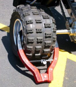 Winner International The Club 491 Tire Claw XL Security Device attached to a wheel.