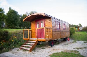 Traveling tiny house - what is it like, a house with wheels in a park.